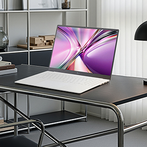 책상위에 LG gram 화이트 노트북이 비스듬하게 펼쳐져 있습니다.