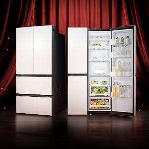 빨간 무대 커튼 앞에 서 있는 두 대의 가전제품. 왼쪽에는 문이 모두 닫힌 베이지 컬러 김치냉장고가 있고, 오른쪽에는 문이 열린 베이지 컬러 냉장고가 놓여 있으며 내부에 음료와 채소, 과일 등이 정리되어 보인다.